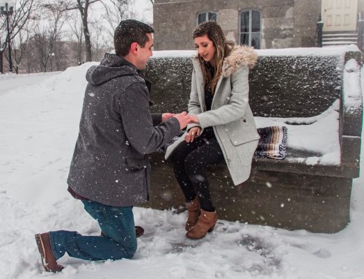 man kneeling to propose in front of woman