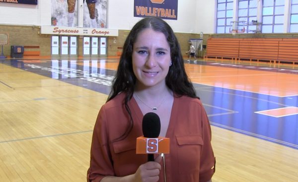 Cuse Cast anchor Elissa Candiotti stands in womens building gym holding cuse cast microphone