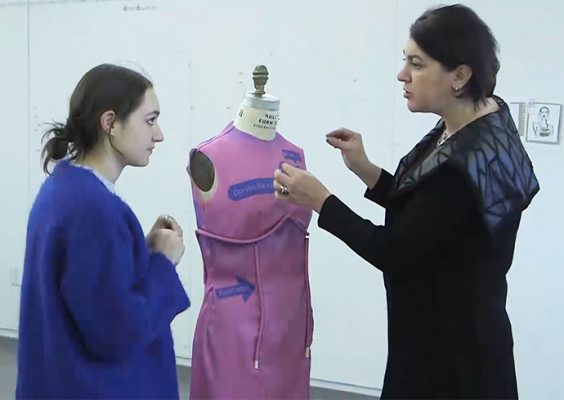 Adriana Gorea on right and student on left conferring over mannequin at center