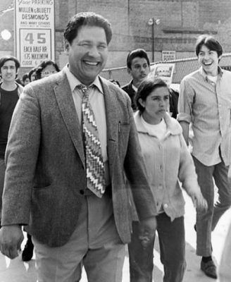 black and white photo of people marching with heavy-set man on the left