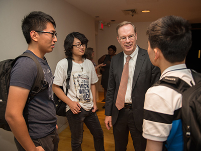 Three male students speaking with Chancellor Syverud