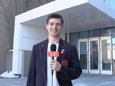 Matt Stedman with microphone standing in front of Newhouse 3
