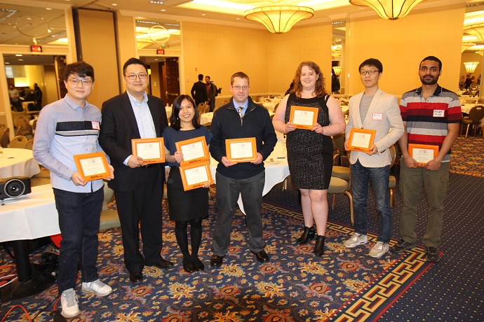 group of people standing with awards