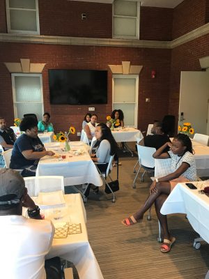 Students sit at set dinner tables for McNair Scholars program in Sims Hall