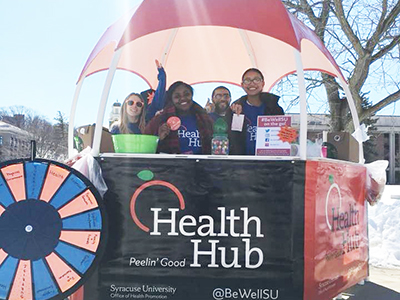 students inside the Health Hub, a stand with plastic roof