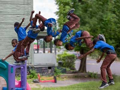 Image of child doing backflip from playground fixture.