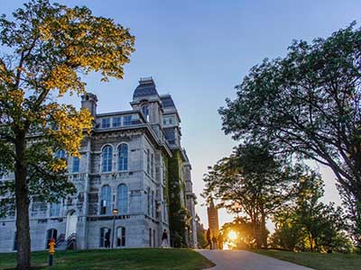 Photo shows sun setting behind Crouse College.