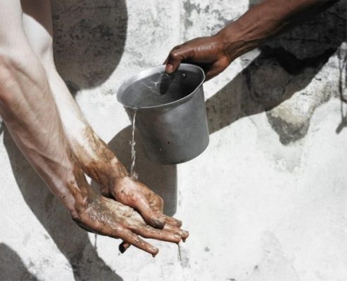 person pouring water over another person's hands
