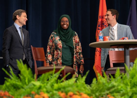 three people standing on stage