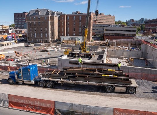 steel beam being carred by crane at construction site