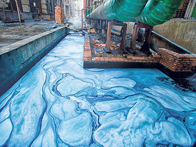 Photo of blue dyed water flowing out of a factory.