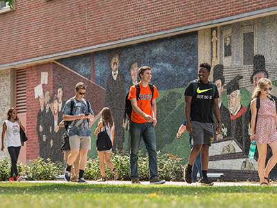Students walking by the Sacco and Vanzetti Mural