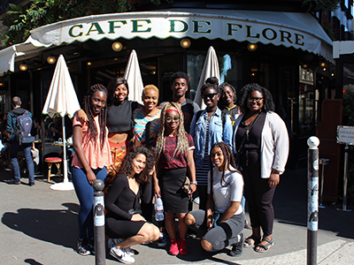 tudents pose outside a Parisian café.