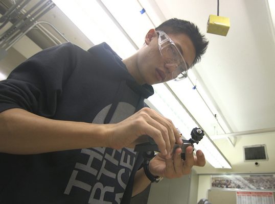man working on small race car