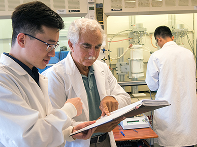Professor Lawrence Tavlarides with students in his lab.