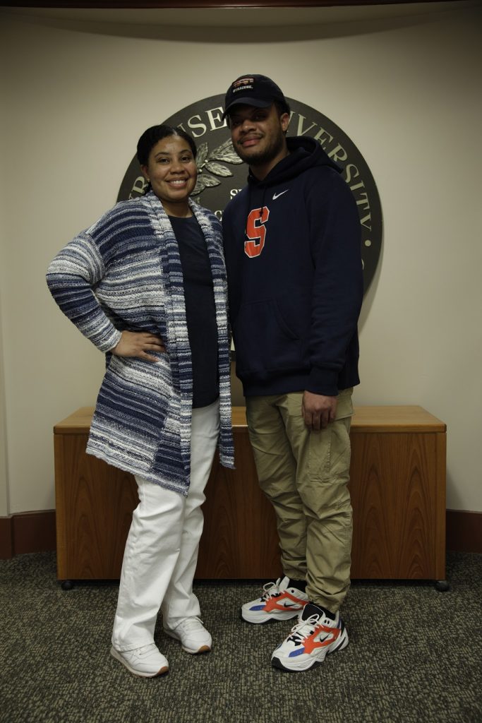 woman and her son standing next to her