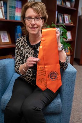Amie Redmond displays a stole presented to her last May by a graduating student whom she had helped through a family tragedy. Written on it are messages from the student (“Thank you for being my biggest support at Syracuse. I couldn't have finished without you.”) and the student’s mother (“Amie, thank you for being you.”).