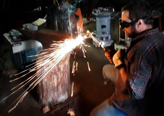 man using oxy-acetylene torch on a piece of metal