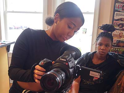 Simone showing student how to use camera