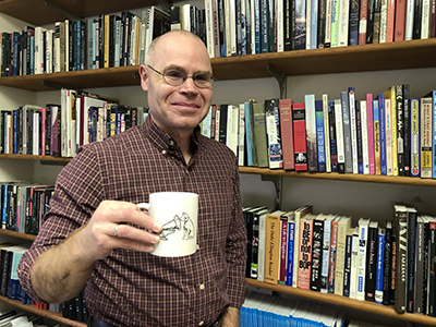 man standing in front of shelves of books