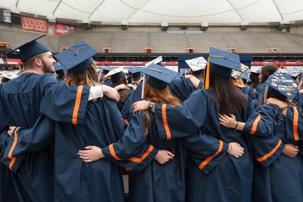 graduates with their arms around each other