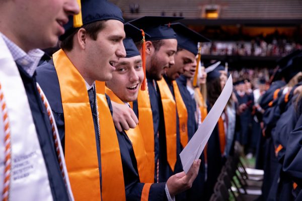 row of graduates singing
