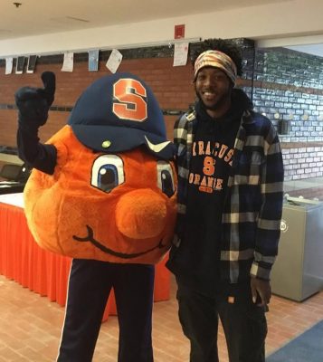 student standing next to Otto the Orange mascot