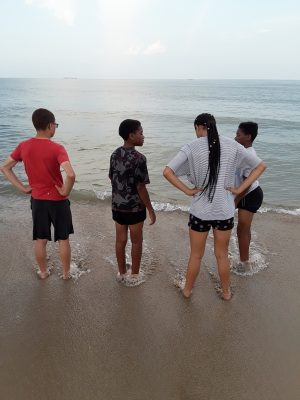 four children standing on beach