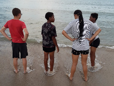 four children standing on beach