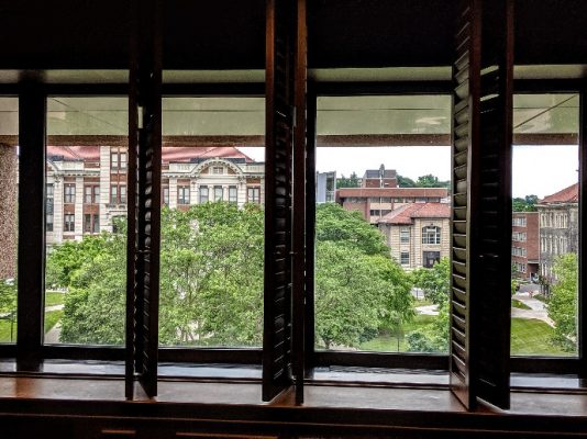 campus view of buildings through interior windows