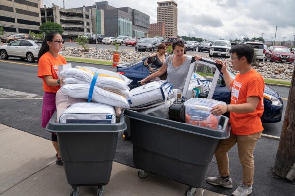 students loading bins with items from new students