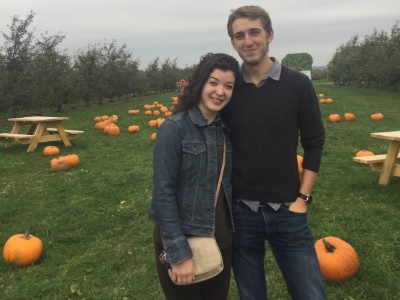 Couple standing in pumpkin patch.