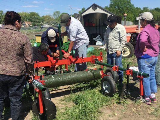 people fixing farm equipment