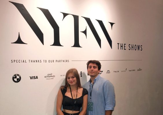 Two students standing in front of New York Fashion Week sign.