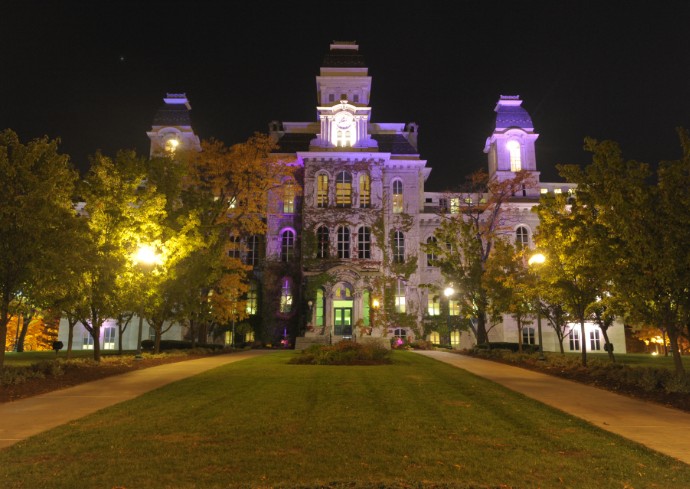 shot of the Hall of Languages at Syracuse University illuminated by purple light