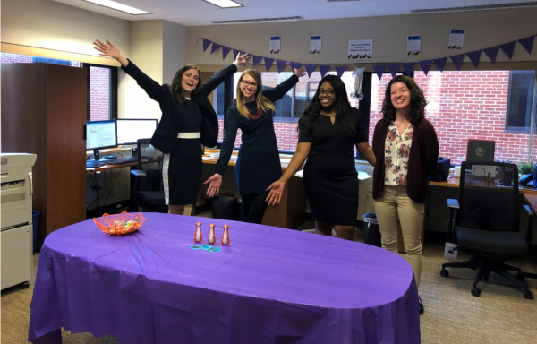 four women in office space with purple decorations