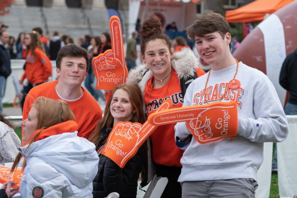 group of people wearing orange foam fingers at football tailgate