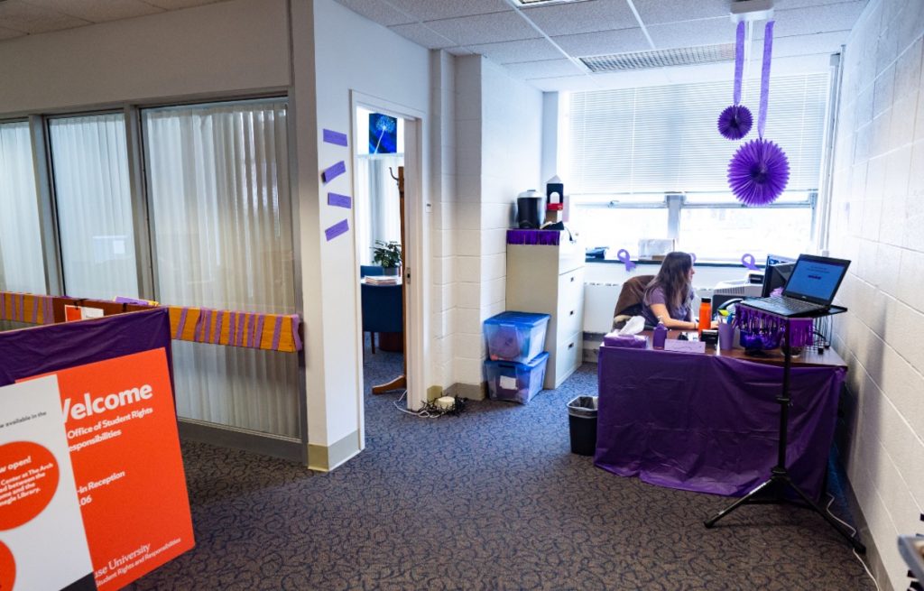 woman sitting at a desk surrounded by purple decor