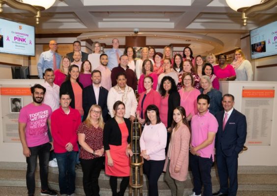 group of staff members wearing pink on stairwell