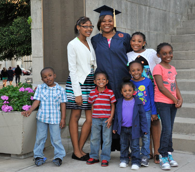 woman in graduation robe with children