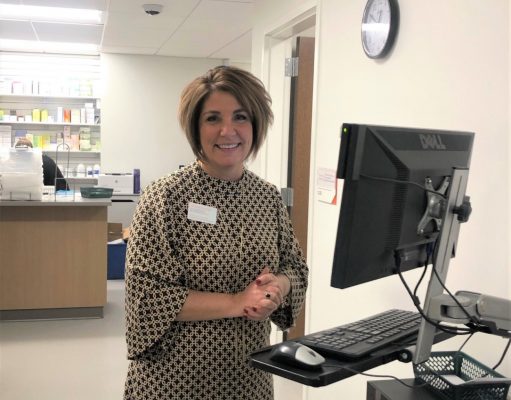 woman pharmacist standing in front of computer