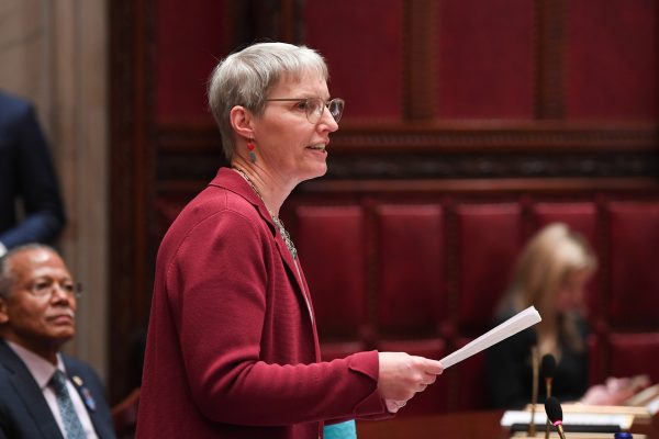 person speaking and holding papers