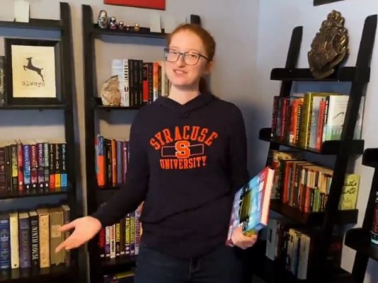 person standing in front of book case