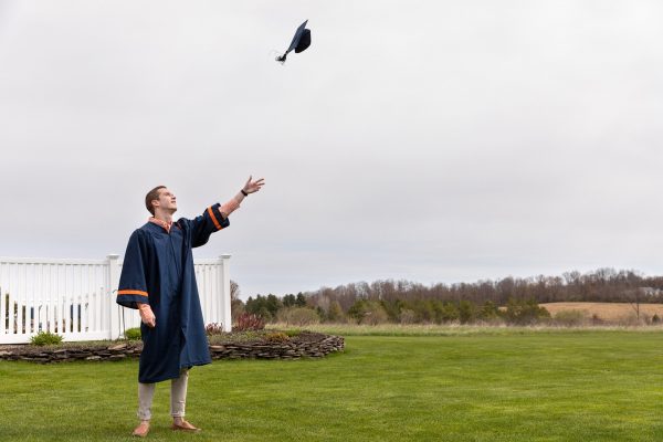 person throwing graduation cap in air