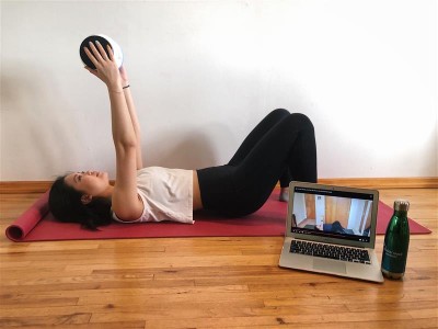 student working out with video playing on laptop
