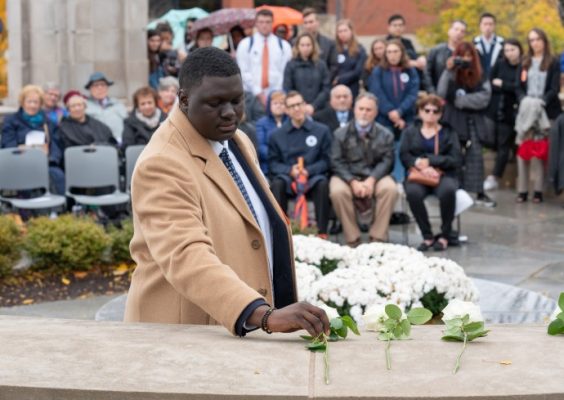 man laying rose at memorial