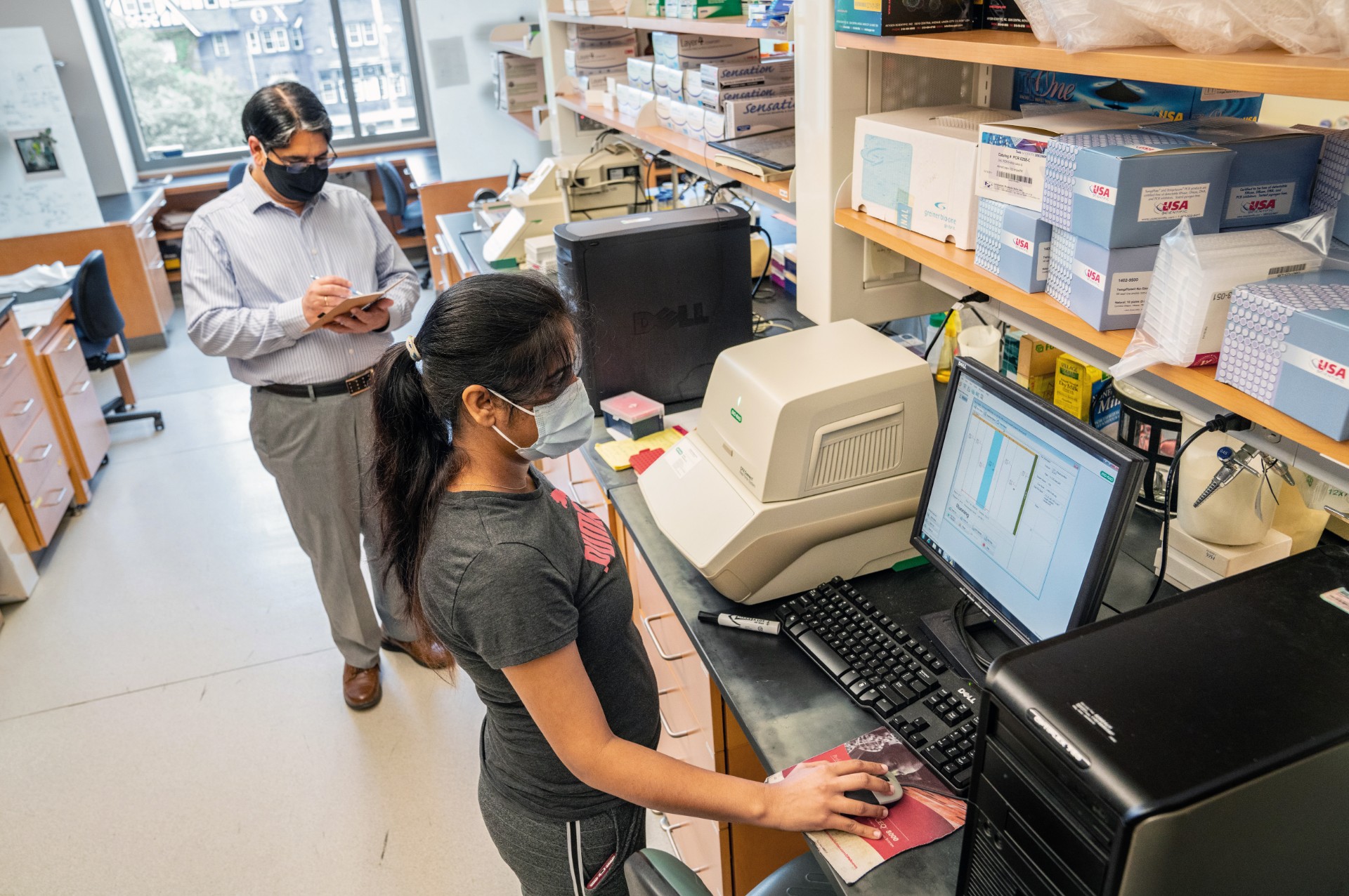 Dr. Ramesh Raina and graduate student Deepjyoti Singh working in a laboratory