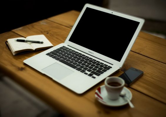 computer and coffee cup on table