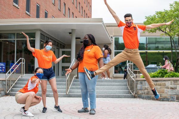 four people posing in front of residence hall