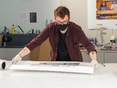 staff member working on a large photo at a table